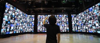 a men attending a webinar on big screens