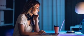 a woman sitting in front of a laptop computer.