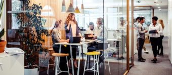 a group of people standing around a glass walled office