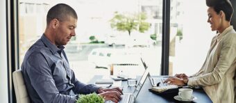 a man and a woman are looking at a laptop