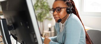 a woman wearing a headset sitting in front of a computer