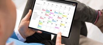 a person holding a tablet with a calendar on it